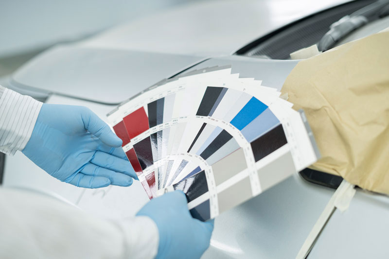 A person in gloves holding color samples